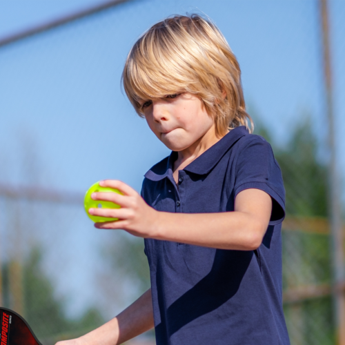 Enfant jouant au pickleball avec une raquette BOOMA