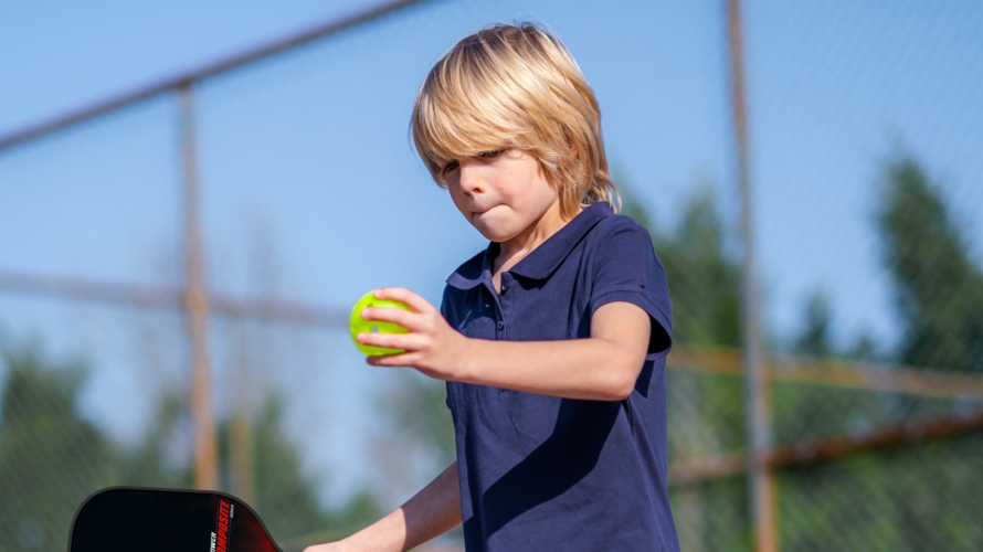Enfant jouant au pickleball avec une raquette BOOMA