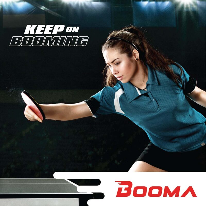 A women with a green t-shirt hitting a ping pong ball.