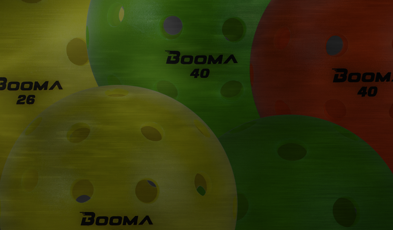 Close up image of BOOMA 40 pickleball balls in orange, green and yellow.