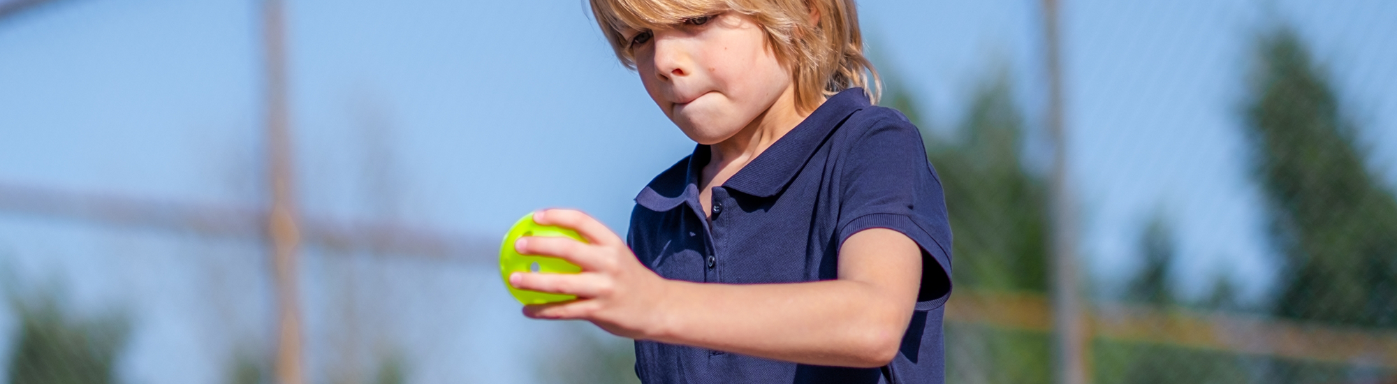 Child playing pickleball getting ready to serve with a BOOMA paddle.