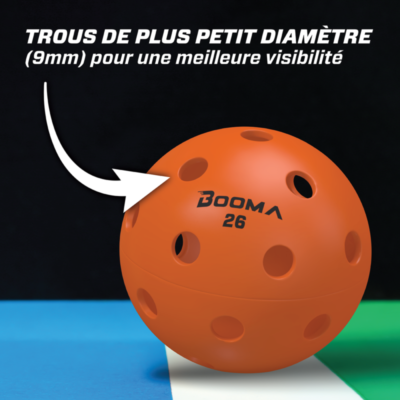 Gros plan d'une balle de pickleball intérieure BOOMA 26 orange avec une flèche mettant en évidence les petits trous.